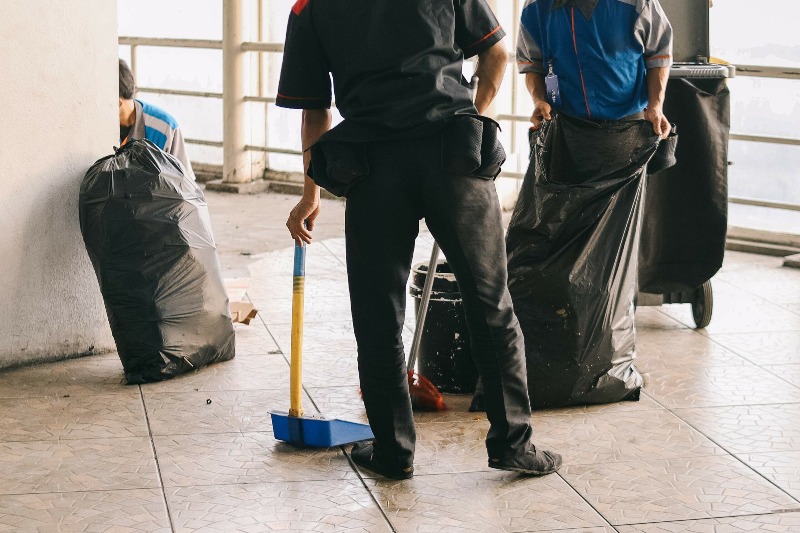 Évacuation des déchets par des professionnels Deux agents de propreté remplissent un sac-poubelle après nettoyage d’un chantier intérieur à Langon ou La Réole
